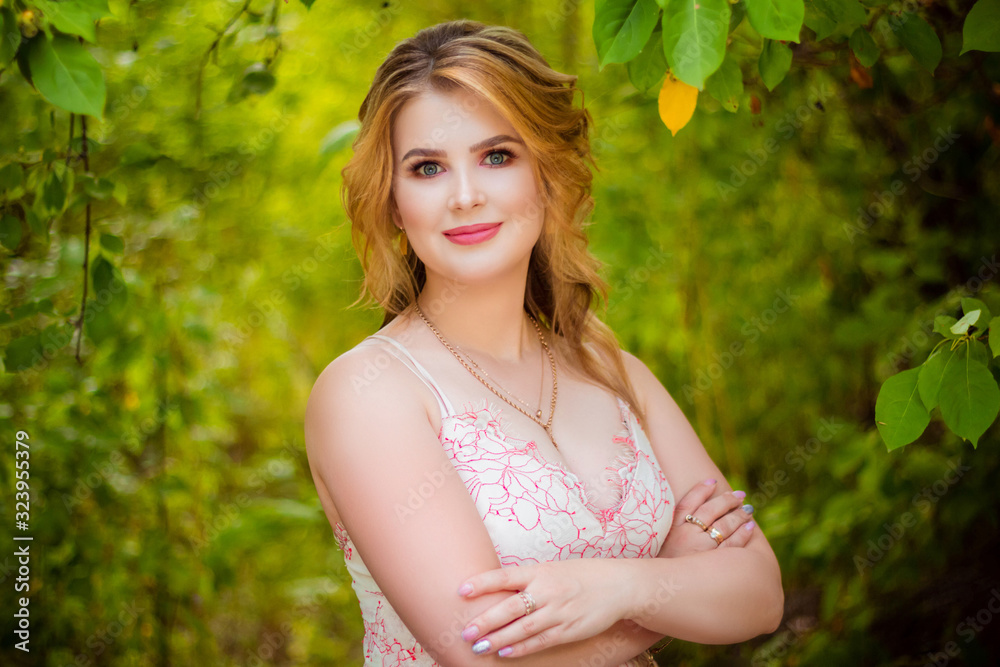 Portrait of an attractive woman in a park on a background of thick foliage. Portrait of an attractive woman in a park on a background of thick foliage.
