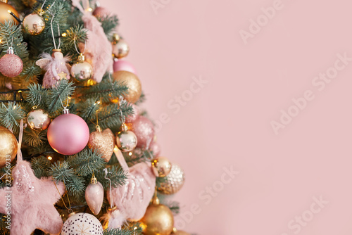 Christmas tree in pink loft style interior. Template Christmas greeting card. Congratulatory New Year greeting card. Pastel colored decoration for christmas. Christmas tree in winter interior bedroom © Aleksandr