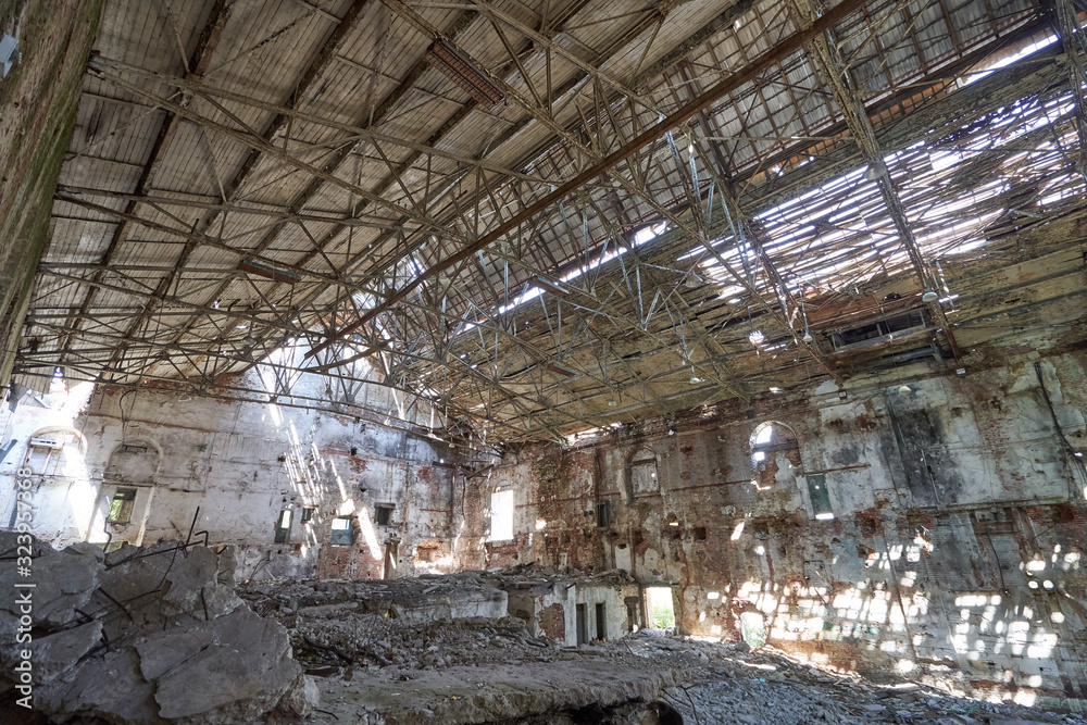 An abandoned, destroyed old factory with holes in the walls and roof.