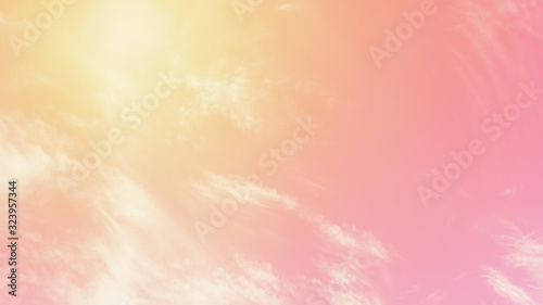 Sunny orange pink sky background. Beautiful warm sky with clouds. Toned photo, 16:9 panoramic format