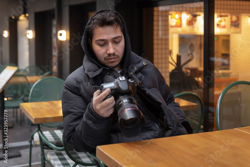 Young photographer looking at his photos on the street