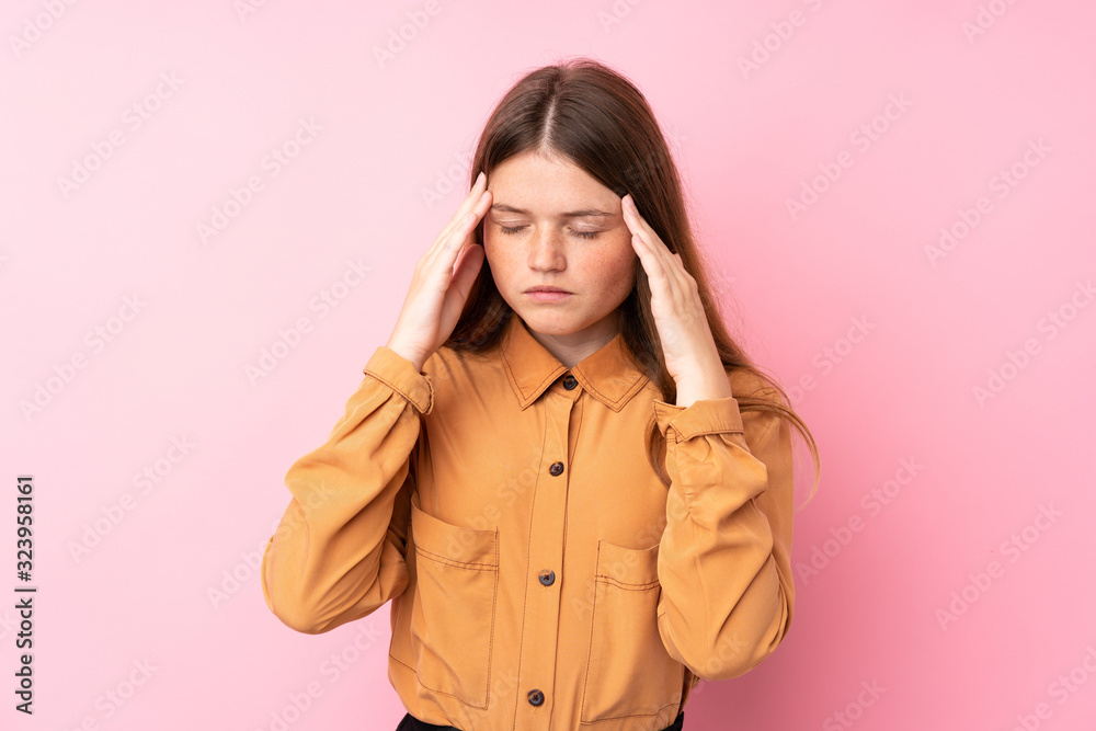 Ukrainian teenager girl over isolated pink background with headache Ukrainian teenager girl over isolated pink background with headache