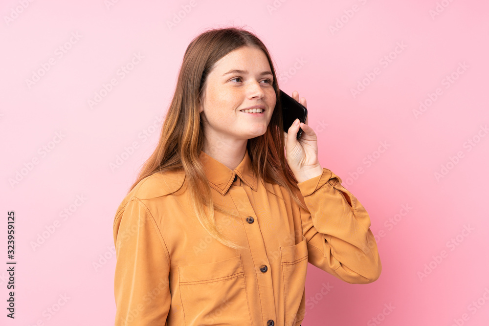 Ukrainian teenager girl over isolated pink background keeping a conversation with the mobile phone Ukrainian teenager girl over isolated pink background keeping a conversation with the mobile phone