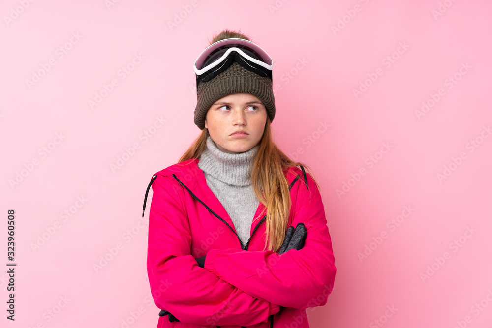 Ukrainian teenager skier girl with snowboarding glasses over isolated pink background thinking an idea