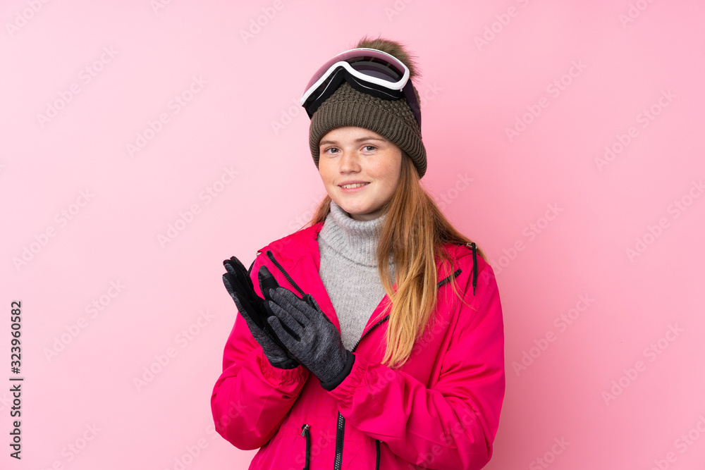 Ukrainian teenager skier girl with snowboarding glasses over isolated pink background applauding Ukrainian teenager skier girl with snowboarding glasses over isolated pink background applauding