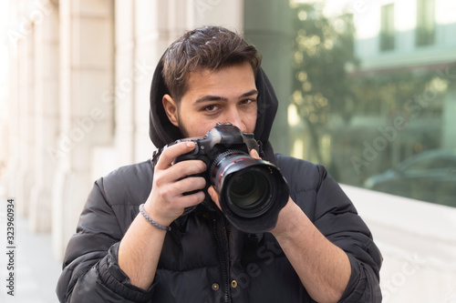 Young photographer taking photos on the streets of the city