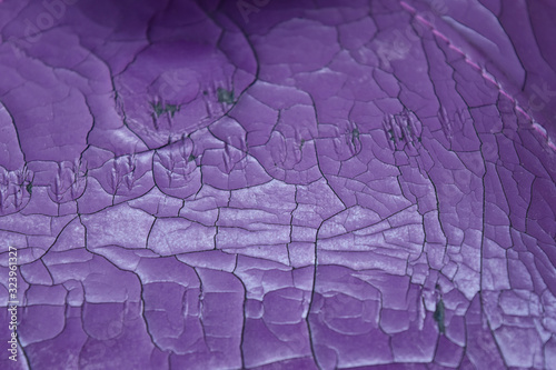 The artificial old leather bag purple. Broken pattern texture background.