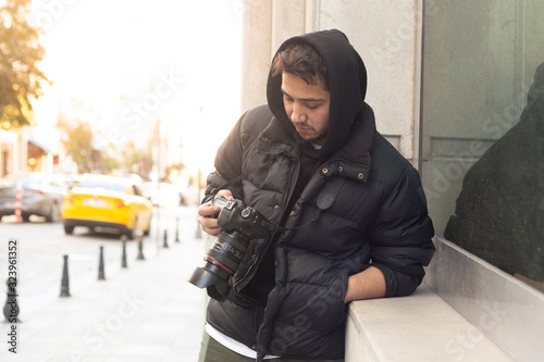 Young photographer looking at his photos on the street photo