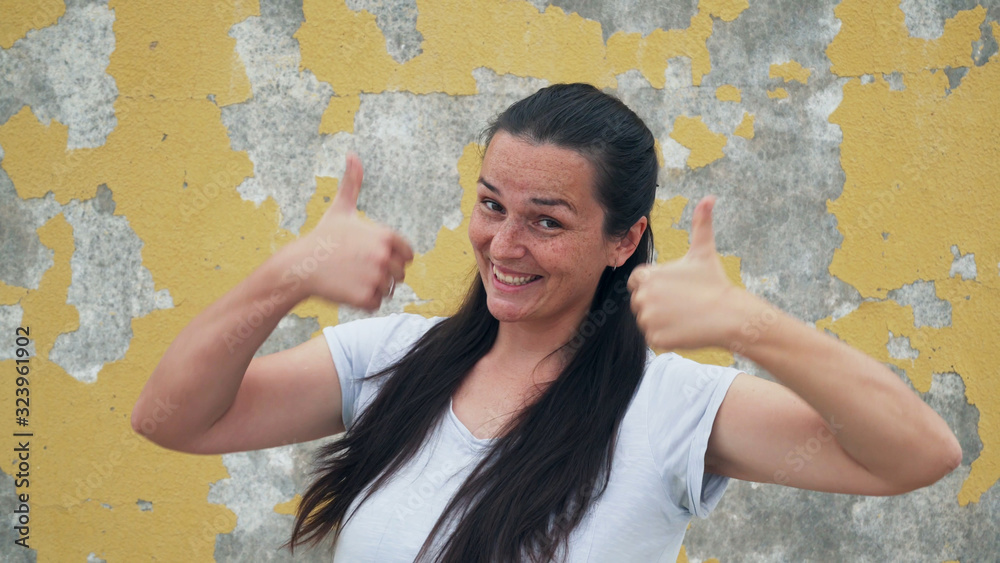 Obraz premium Portrait of handsome girl with freckles playful showing thumb up both hands