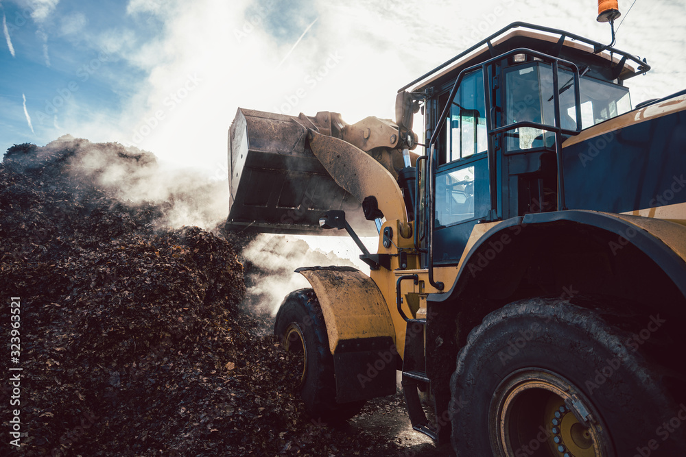 Earth mover working on pile of compost Earth mover working on pile of compost