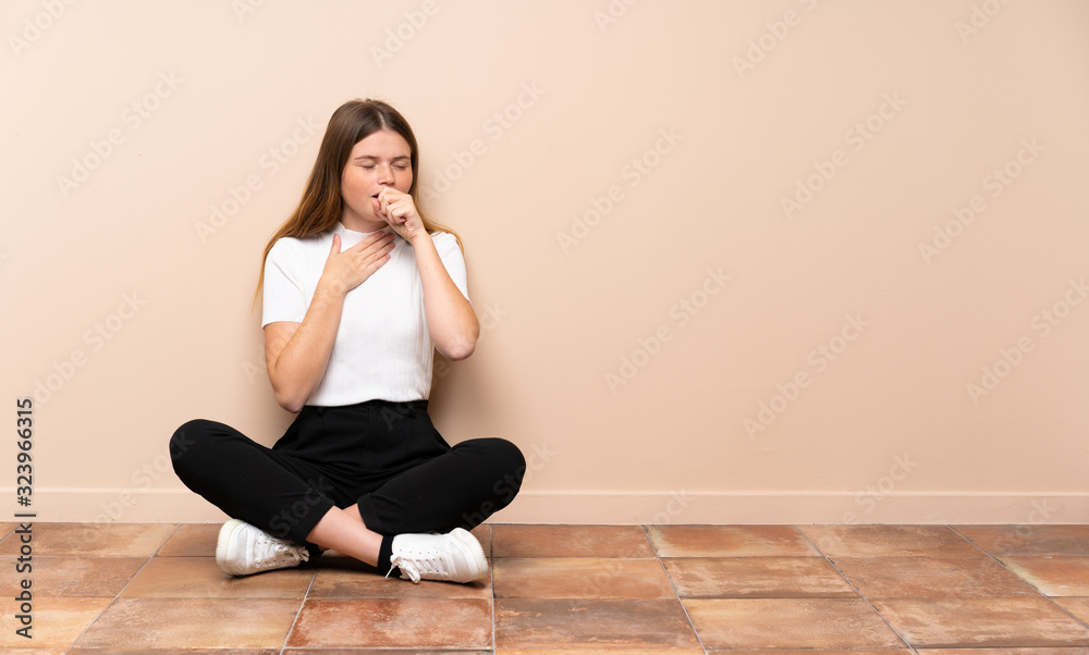 Ukrainian teenager girl sitting on the floor is suffering with cough and feeling bad Ukrainian teenager girl sitting on the floor is suffering with cough and feeling bad