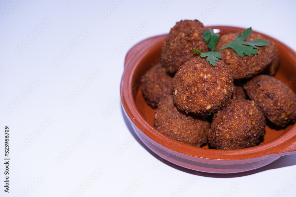 Chickpeas falafel on a clay bowl isolated in white backgorund. Close up view. Copy space.