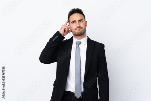 Young business man over isolated background having doubts and with confuse face expression