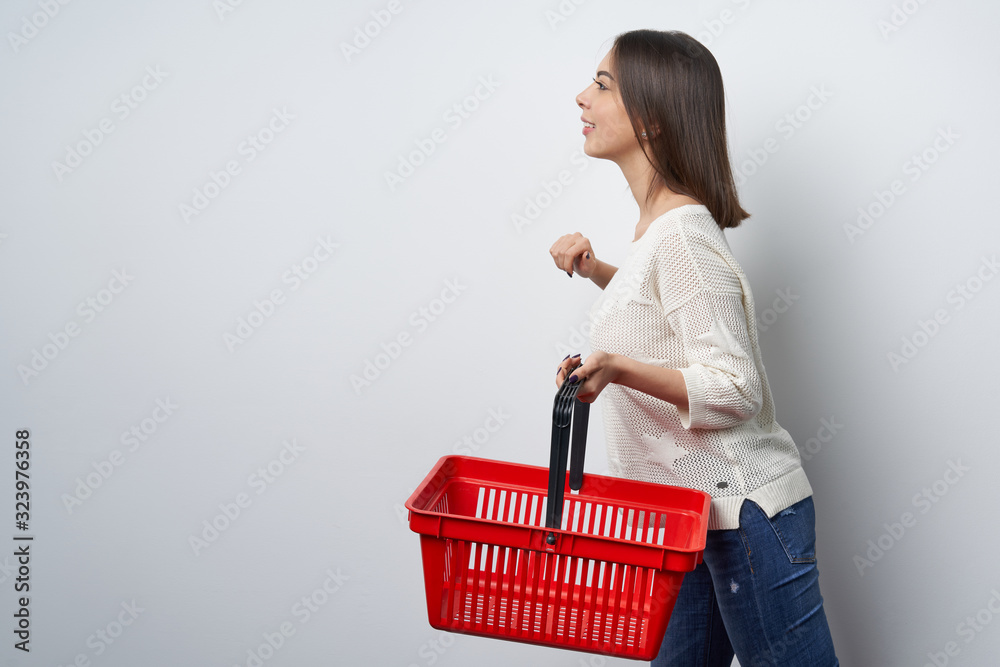 Smiling brunette woman walking with empty shopping basket Smiling brunette woman walking with empty shopping basket
