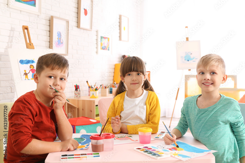Fototapeta premium Cute little children painting at table in room