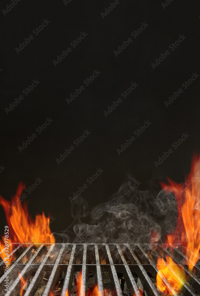 Hot empty barbecue BBQ grill with bright flaming fire, ember charcoal and smoke on black background. Waiting for the placement of your food. Close up