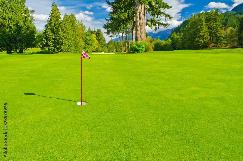 Obraz premium Golf place with gorgeous green and fantastic mountain and blue sky view