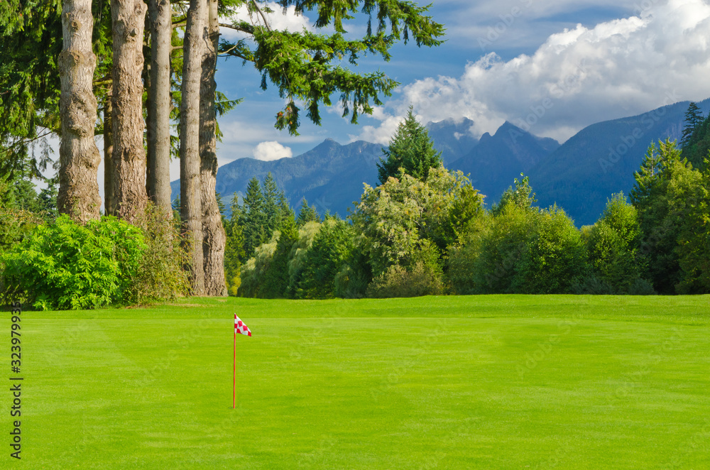 Obraz premium Golf place with gorgeous green and fantastic mountain and blue sky view