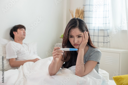 Wall Mural Stress wife worried about disappointed pregnancy with blurred frustrated husband