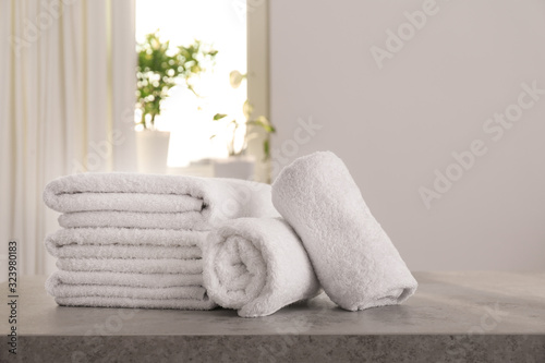Fresh towels on light grey stone table in bathroom