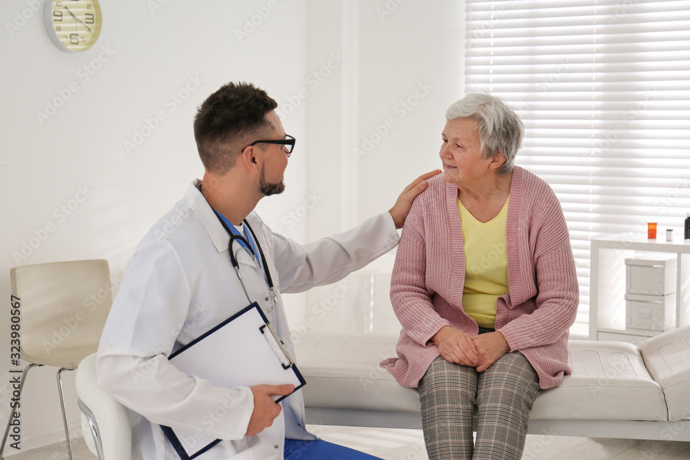 Fototapeta premium Doctor examining senior patient in modern office