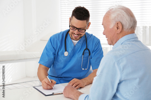 Doctor examining senior patient in modern office