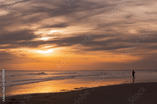 Man in silhouette on sandy beach at sunset © Brandy