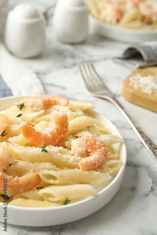 Delicious pasta with shrimps served on white marble table Delicious pasta with shrimps served on white marble table