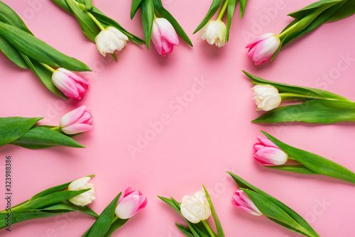 Fototapeta Naklejka Na Ścianę i Meble -  Top view of round frame with tulips on pink background