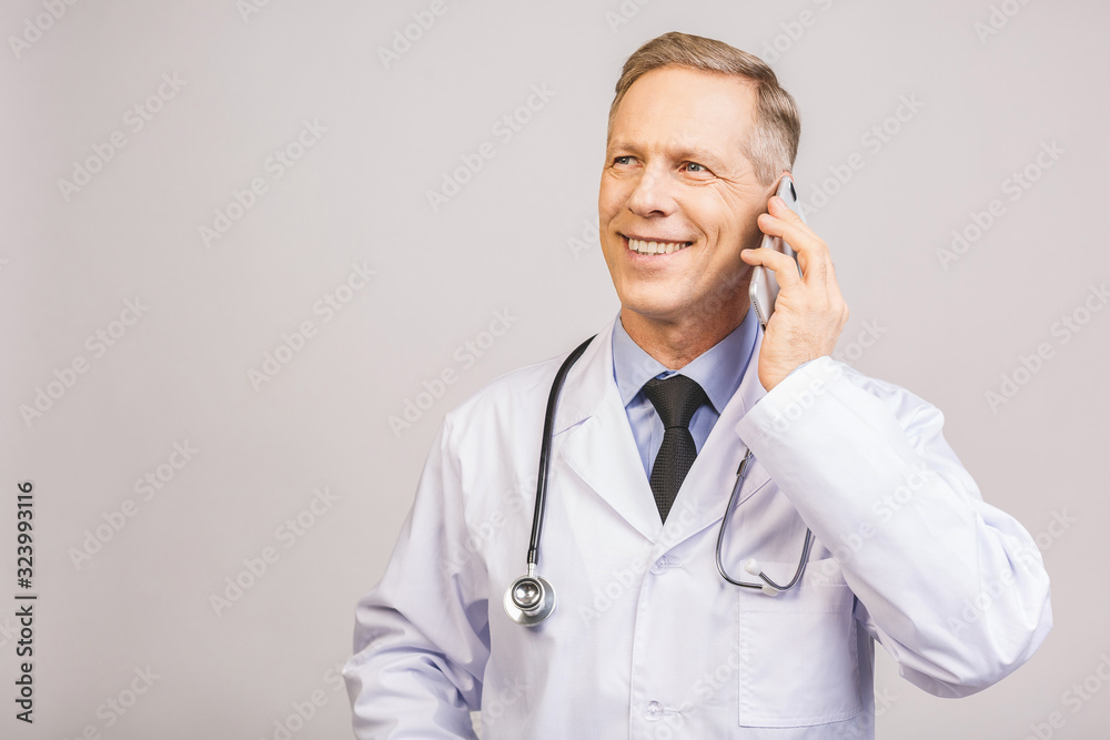 Closeup photo of senior man doctor standing isolated on grey background, using mobile phone. Closeup photo of senior man doctor standing isolated on grey background, using mobile phone.