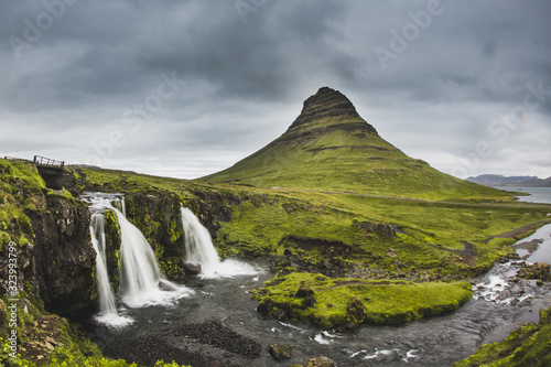 Kirkjufellsfoss waterfall and Kirkjufell mountain behind. On very cloudy and rainy day at Iceland. Beautiful landscape