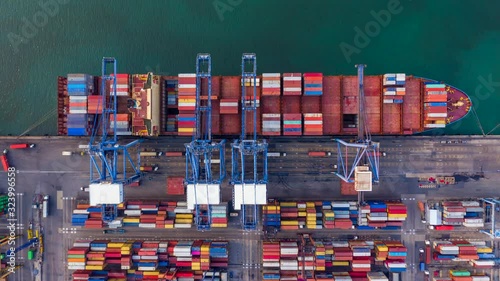 Container ship loading and unloading in deep sea port, Aerial view container shipyard business logistic import and export cargo freight ship, transportation by container ship in open sea, Time lapse.