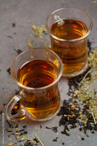 glass cups with tea and tea leaves on a dark background