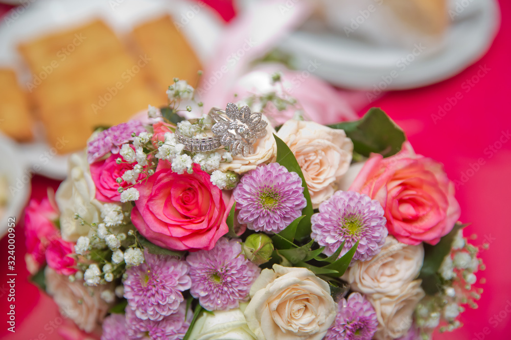 close up wedding ring on top of a colorfull bouquet. . macro .Close up of wedding rings on the bouquet . Macro . Bride and groom with Engagement gold rings put on the clorfull wedding bouquet . close up wedding ring on top of a colorfull bouquet. . macro .Close up of wedding rings on the bouquet . Macro . Bride and groom with Engagement gold rings put on the clorfull wedding bouquet .