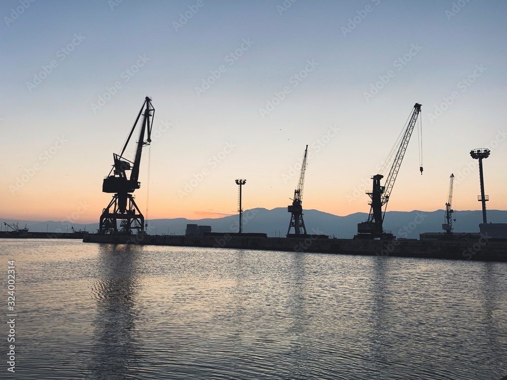Silhouettes of the cranes in the sea port