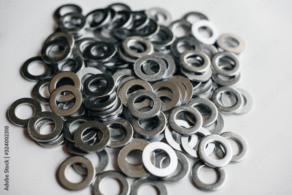 Pile of washers, bolts and nuts on a light background close-up Pile of washers, bolts and nuts on a light background close-up