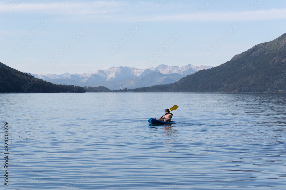 Joven disfrutando las vacaciones de verano en su canoa. 