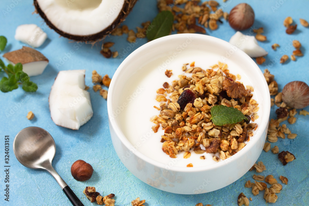 Homemade healthy breakfast. Bowl with homemade baked coconut granola and greek yogurt on a turquoise stone or concrete table. Homemade healthy breakfast. Bowl with homemade baked coconut granola and greek yogurt on a turquoise stone or concrete table.