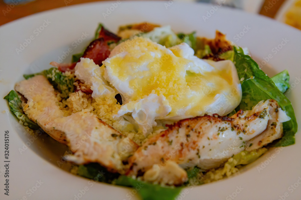 Close up shot of a plate of traditional egg and fried chicken breast