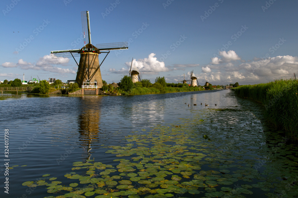  Landscape with windmills  on a bright and sunny day at the Kinderdijk. Recreation area with 19 windmills.Travel in Netherlands.  Travel, sightseeing and tourism. 