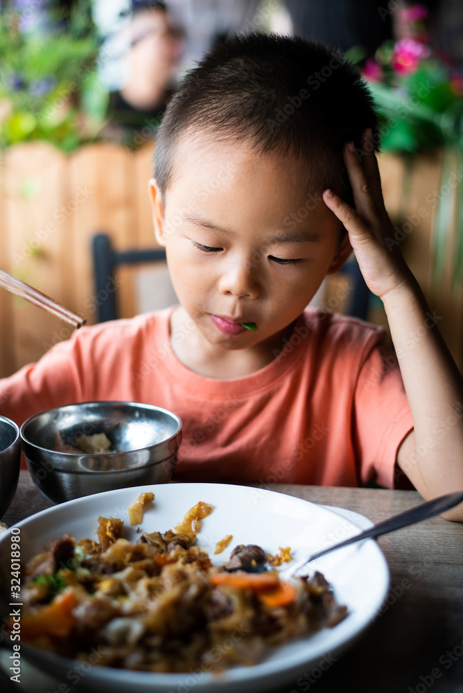 Asian boy having lunch at the restaurant Asian boy having lunch at the restaurant