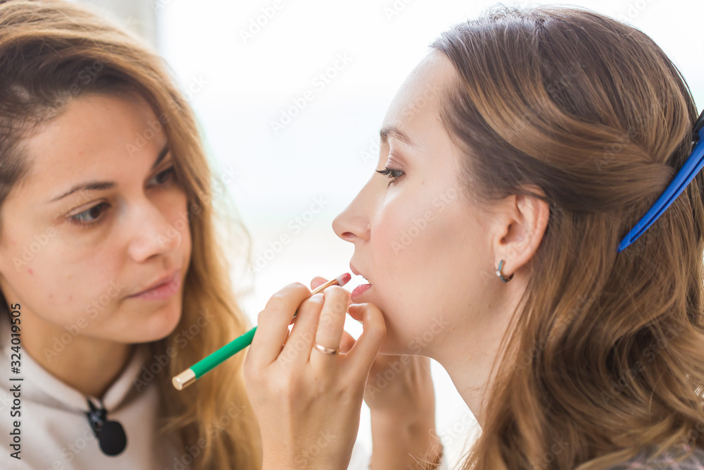 Beauty and cosmetics concept - Make-up artist doing professional make up of young woman Beauty and cosmetics concept - Make-up artist doing professional make up of young woman