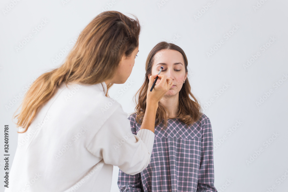 Beauty and cosmetics concept - Make-up artist doing professional make up of young woman Beauty and cosmetics concept - Make-up artist doing professional make up of young woman