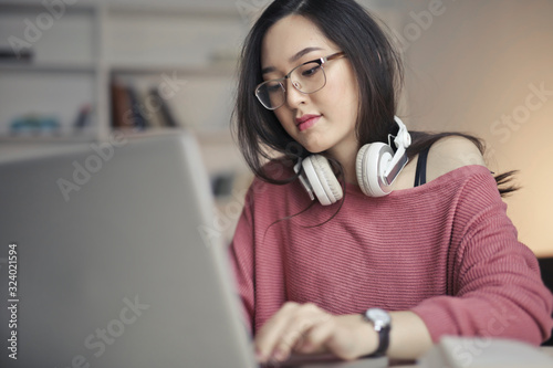 young asian woman works with laptop photo