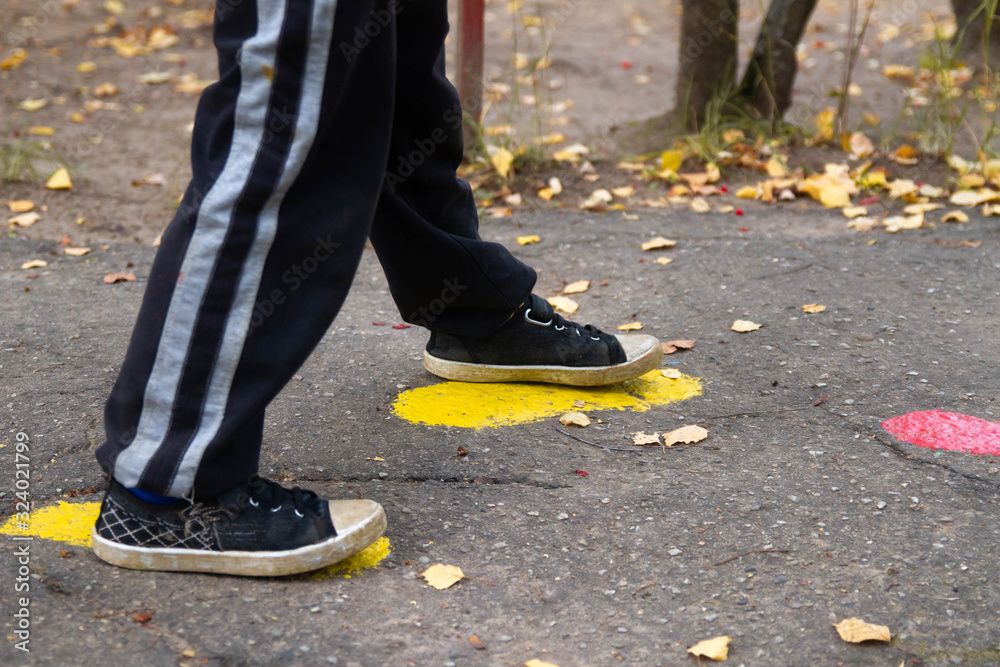 The boy follows the tracks on the pavement. Traces of paint on the road. The boy follows the tracks on the pavement. Traces of paint on the road.