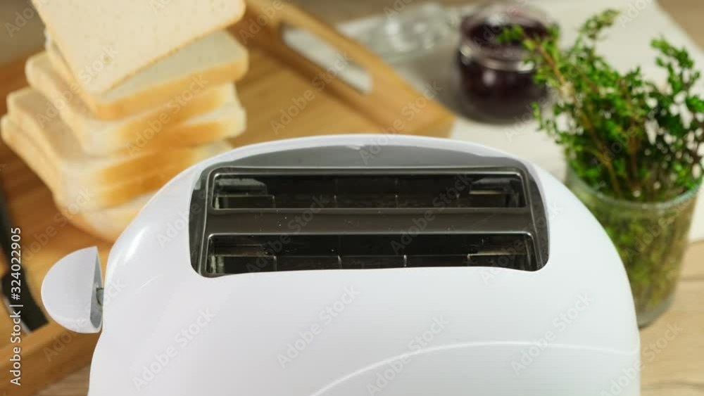 White toaster prepares bread for breakfast. Close up. White toaster prepares bread for breakfast. Close up.