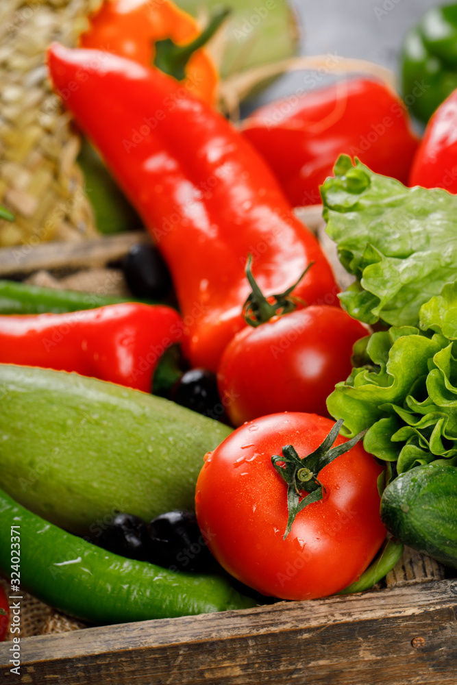 Red and green vegetables in a wooden tray.