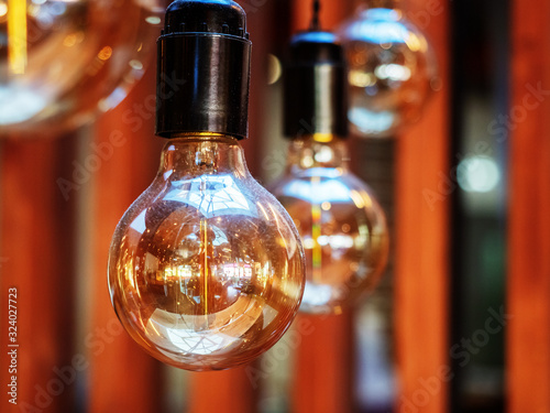 Close-up photo of hanging light bulbs with interior reflected in them
