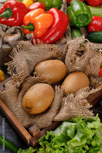 Kiwies on a burlap with color peppers around. photo