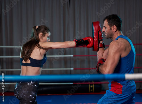 Kickboxing girl hitting mitts © Xalanx